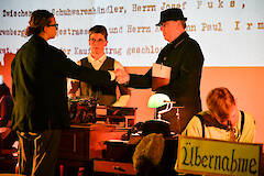 In einem Theaterstück in Spremberg wird die Geschichte von Chaim Jossek und seiner Familie erzählt. Hier unterzeichnet er den Kaufvertrag mit dem Schuhhändler Paul Irmler, März 2026