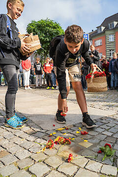 Die Schüler legen Blumen ab.